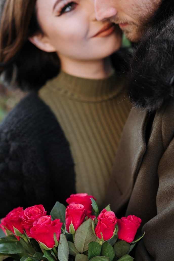 A person holding a bouquet of rosesDescription automatically generated